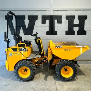 Yellow JCB site dumper parked indoors against a wall with large black lettering