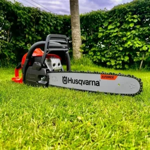 Husqvarna chainsaw lying on grass in a garden