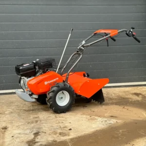 Orange Husqvarna TR 348 tiller with handles and large treaded wheels