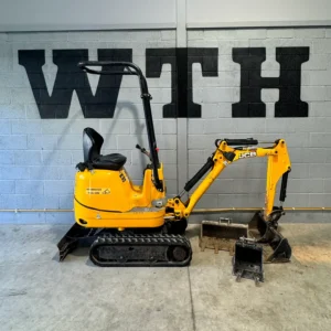 Yellow JCB mini excavator with attachments in a workshop