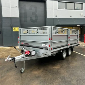 Twin-axle tipper trailer parked outside a warehouse