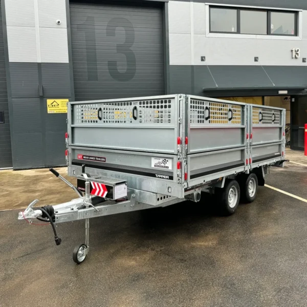 Twin-axle tipper trailer parked outside a warehouse
