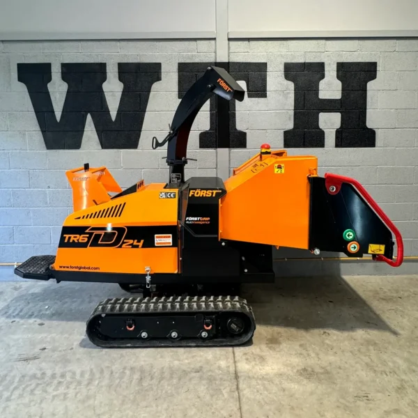 Tracked wood chipper in orange and black, branded Först, shown indoors against a wall